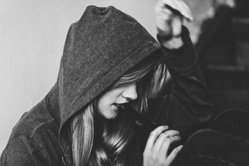 Naklejka premium Black and white picture of teen girl drinking alcohol. Teenage alcoholism issue.