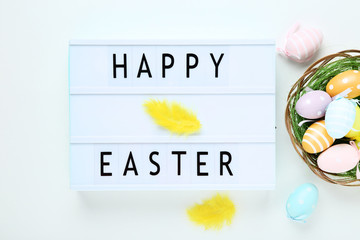 Lightbox with words Happy Easter with colorful eggs on white background