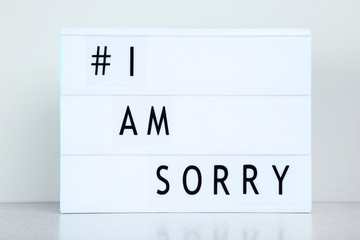 Lightbox with words I Am Sorry on grey background