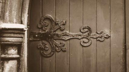 Decorative Ironwork on Wooden Door in Sepia Tone