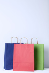 Colorful paper shopping bags on grey background