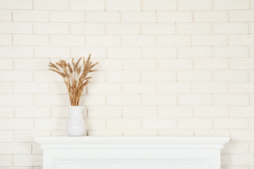 White fireplace with wheat ears in vase