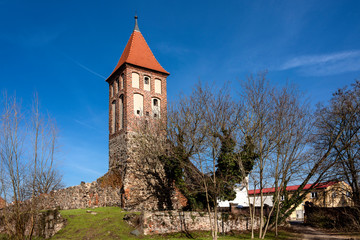 Fototapeta na wymiar Germany, Brandenburg, Jueterbog: Panorama view of historic tower as part of the old city wall in the city center of the German town with park and blue sky in the background - concept travel history