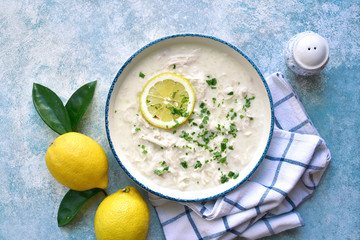 Avgolemono - traditional greek chicken soup with orzo pasta, eggs and lemon.Top view with copy...