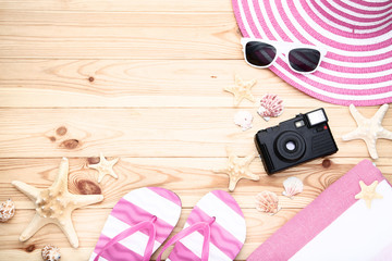 Different seashells with clothes and retro camera on wooden table