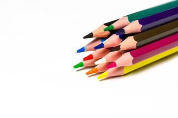 Colourful sharp pencils lie on a white background