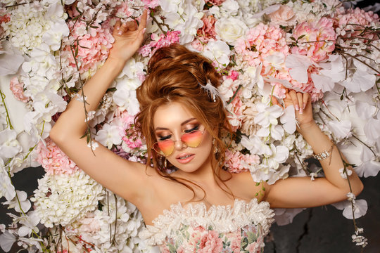 Luxury model in vintage style. Beautiful woman with a stunning hairstyle and make-up in a rococo dress. Girl at the Masquerade Spring Ball
