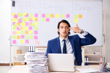 Young handsome employee in front of whiteboard with to-do list  