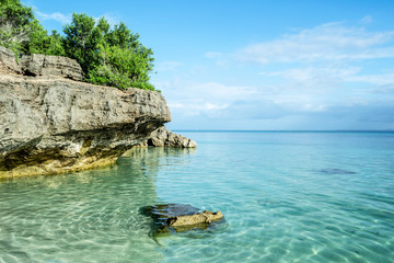 Rocky coast of Bantayan Island in Philippines with clear sea water and tropical beach