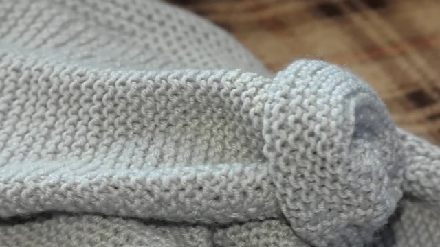 Knitted fabric wool texture close up as a background. knitted warm sweaters, cozy composition in a homely atmosphere. home hobbies, cozy knitted sweaters in the living room on the couch