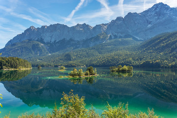 Garmisch-Partenkirchen - View to Lake Eib with a group of trees reflected in the water and...