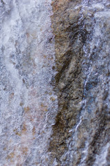 Fototapeta premium Icicles on granite rocks. Frozen water on stones. Clear water in winter. Freshwater source in mountains