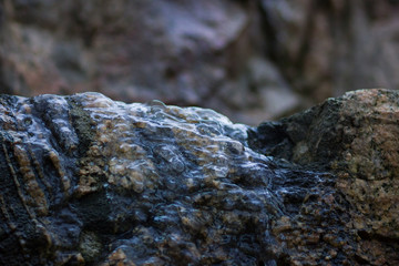 Icicles on granite rocks. Frozen water on stones. Clear water in winter. Freshwater source in mountains