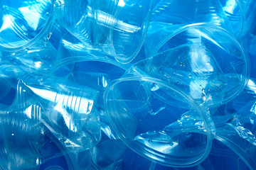 Plastic glass used for drinking water on blue background