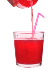 fresh fruit juice is poured from a bottle in the glass with a straw isolated on a white background