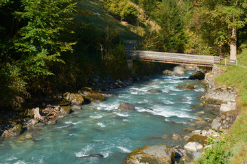 Mountain river with wooden bridge near the village of Lauterbrunnen in Switzerland.