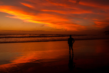 Fototapeta na wymiar Young man walking outdoors watching the sunset at a beach. Thinking and relaxing concept.