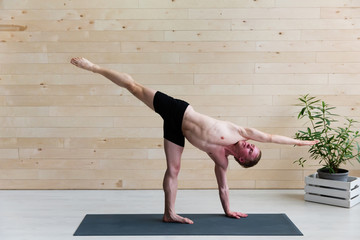 Sporty man practicing yoga on yoga class