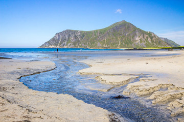 Fototapeta na wymiar Skagsanden beach and mountains and rays of the sun in Lofoten in Norway