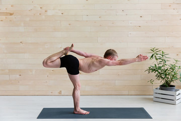 Sporty man practicing yoga on yoga class