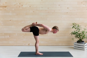 Sporty man practicing yoga on yoga class
