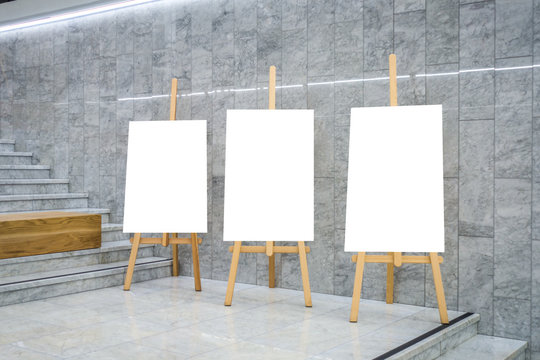 Blank art board canvas on wooden easels in exhibition gallery