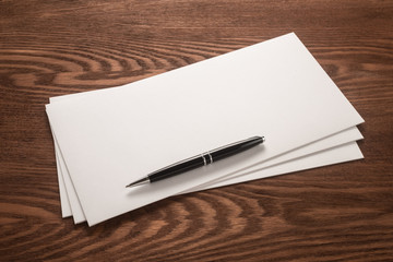 White envelopes and pen on a dark background