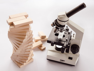 A light microscope for studying microbiology and pharmacology is located in the laboratory next to the DNA model on a light background.