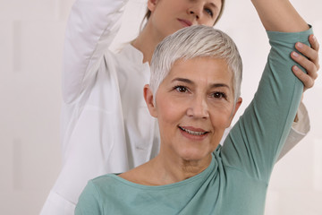 Mature Woman having chiropractic back adjustment. Osteopathy, Physiotherapy, Sport injury...
