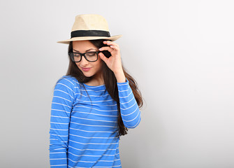 Happy thinking casual woman in eye glasses and straw hat looking down with natural emotional face.