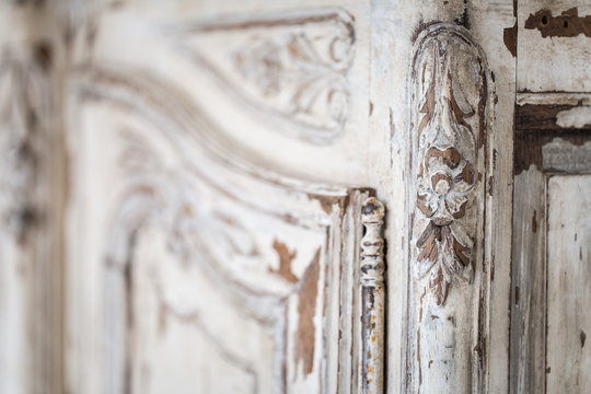 Vintage chest of drawers with carving white color with fading and metal handle. Close-up. Selective focus