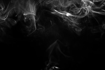 Vape smoke clouds isolated on black background. Hot vape liquid splash in vape coil. Nice aromatic cloud. Low light black and white monochrome photo. Underexposed photo in a low key style.