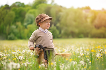 Child and spring. Boy, 4 years old, on a meadow among spring flowers, blooming cherry, grasses, sunny, warm day. Idyll, peace, joy of childhood.