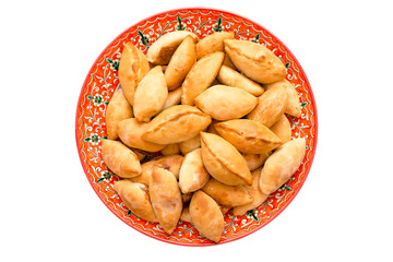 Large painted dish with homemade pies on white isolated background