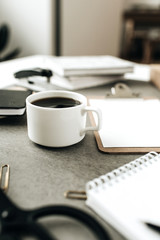Coffee cup on home office desk with stationery.