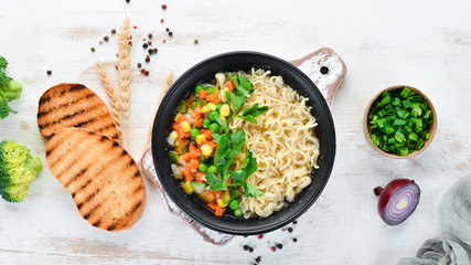 Asian soup with noodles and vegetables in a bowl, with toast bread. Dietary food. Top view. Free copy space.