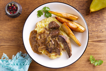 Beef liver with pears and mashed potato. View from above, top studio shot