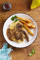 Beef liver with pears and mashed potato. View from above, top studio shot