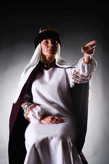 Imperious monarch woman in exquisite costume gesticulating and giving commands