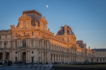 Fototapeta na wymiar Paris, France - 02 17 2019: The roofs of the buildings of the Louvre Museum at sunset with moon