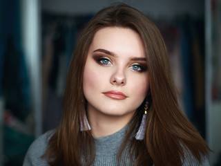 Young beautiful woman with professional make up and hairstyle with domestic room blurry background