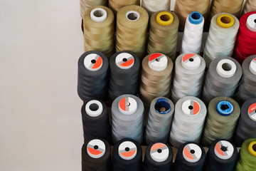 Spools of thread on a stand in a sewing workshop.