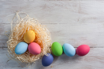 Painted eggs on white wooden boards