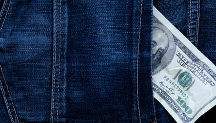 One hundred US Dollar in jeans pocket. Free space for text.