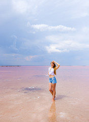 Obraz na płótnie Canvas Girl in shorts and t-shirt on the pink salty lake 