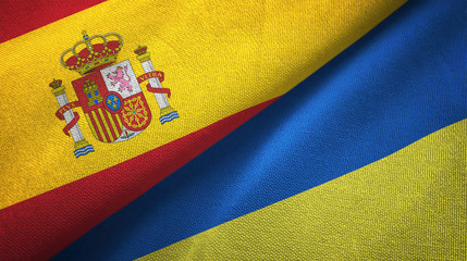 Spain and Ukraine two flags textile cloth, fabric texture