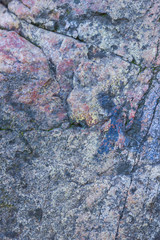 Texture of granite close up. Granite rock with reddish color. Background from solid stone. Pattern with natural material