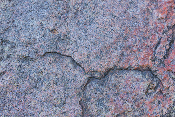 Texture of granite close up. Granite rock with reddish color. Background from solid stone. Pattern...
