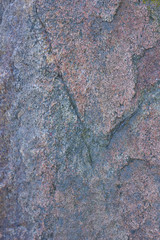 Texture of granite close up. Granite rock with reddish color. Background from solid stone. Pattern with natural material