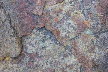 Texture of granite close up. Granite rock with reddish color. Background from solid stone. Pattern with natural material